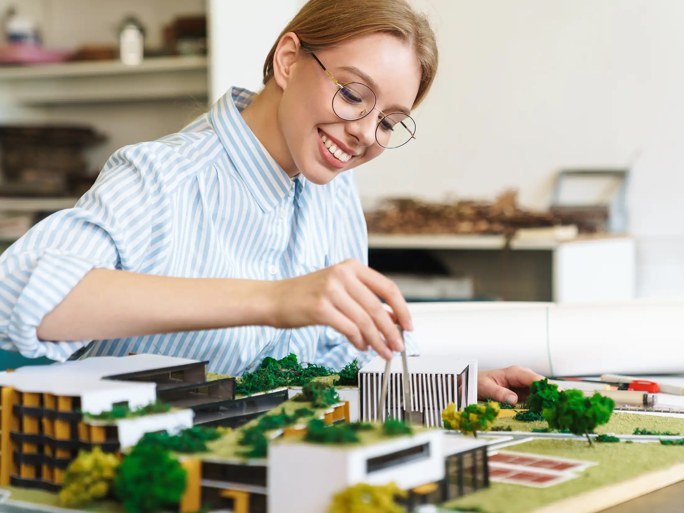 architect designing draft with house model